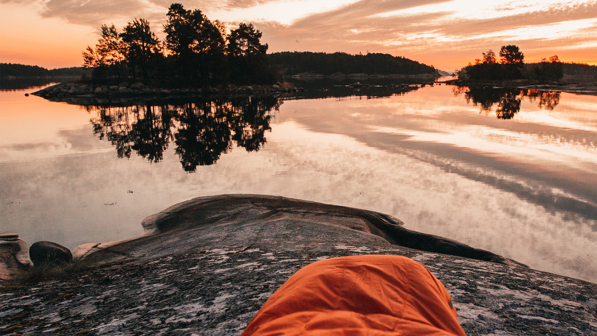 Ein Schlafsack vor einem See im Sonnenuntergang für die Jack Wolfskin Kampagne #GOBACKPACK