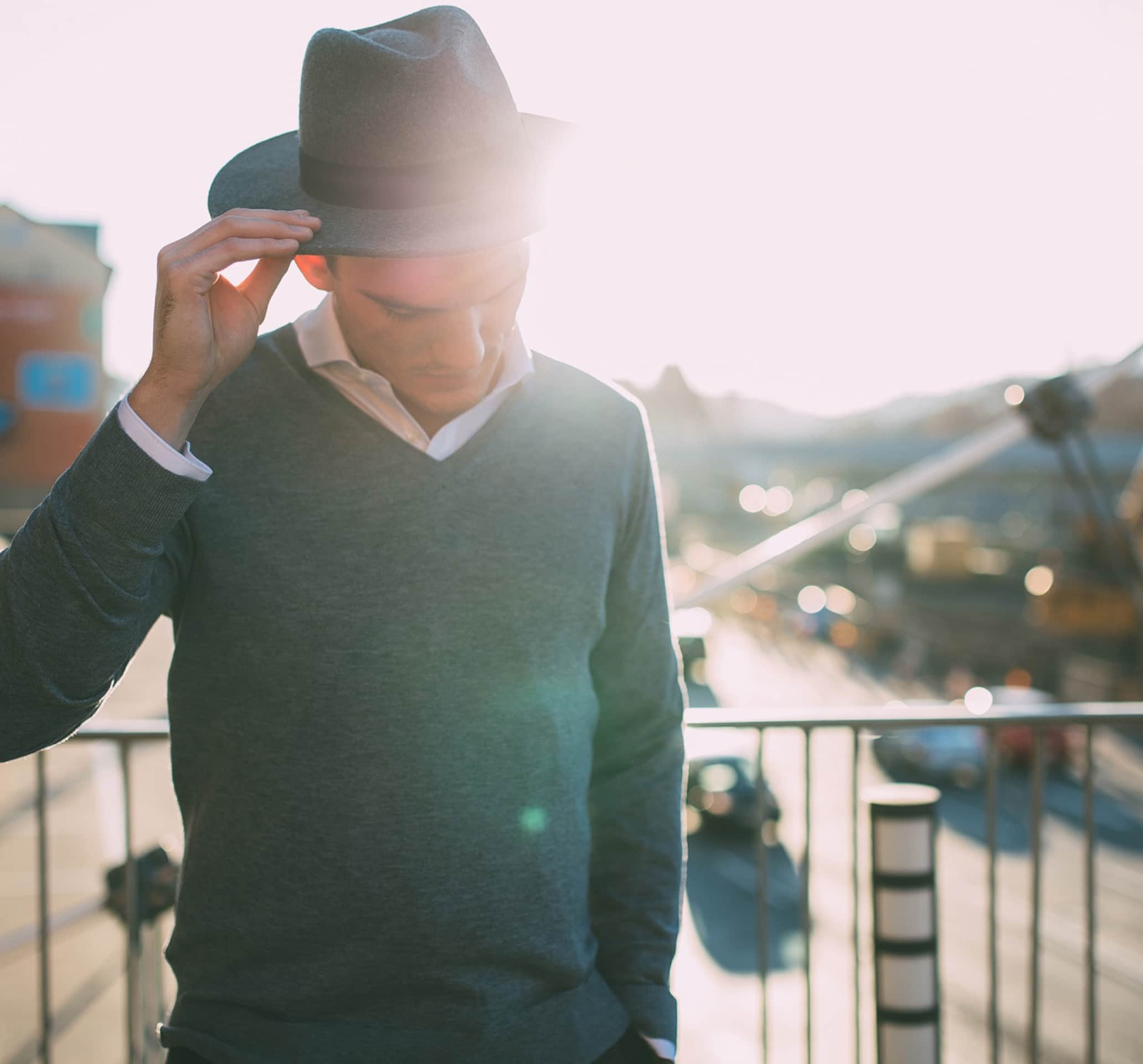Ein gut gekleideter Mann mit Hut steht auf einer Brücke für den Relaunch des digitalen Markenauftritts des Unternehmens Olymp